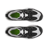 Black and white sneakers with green accents on a white background