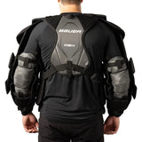 Person wearing a black and gray Bauer protective sports vest on a white background