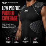 A close-up of a person wearing a black athletic compression shirt with gray padded shoulder and rib areas. The image includes marketing text and icons for McDavid low-profile padded coverage, with the McDavid logo visible on the shirt and in the top left.