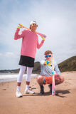 Two people on a beach with colorful sports equipment