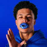 Person wearing a blue mouthguard with a blue background