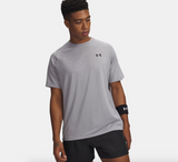Man wearing a gray Under Armour t-shirt and black shorts on a white background