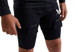 Close-up of a person wearing black athletic compression shorts with side cargo pockets and a white logo on the upper right hip, photographed against a plain white background.