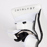 Close-up of a white hockey glove with black trim and the brand name 'CATALYST' printed on the back, set against a light gray background.