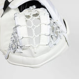 Close-up of a white hockey glove showing the padded wrist area, lace-up front, and hockey net with white and black patterned cords on a light gray background.