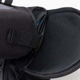Close-up of a black backpack with a shoulder strap on a light gray background