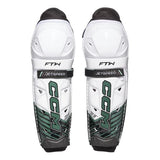 Pair of white hockey shin guards with black and green accents on a white background