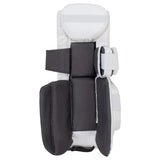 A hockey goalie pad shown from the back, featuring dark gray padded panels, white plastic shell, and white straps with reflective detailing.